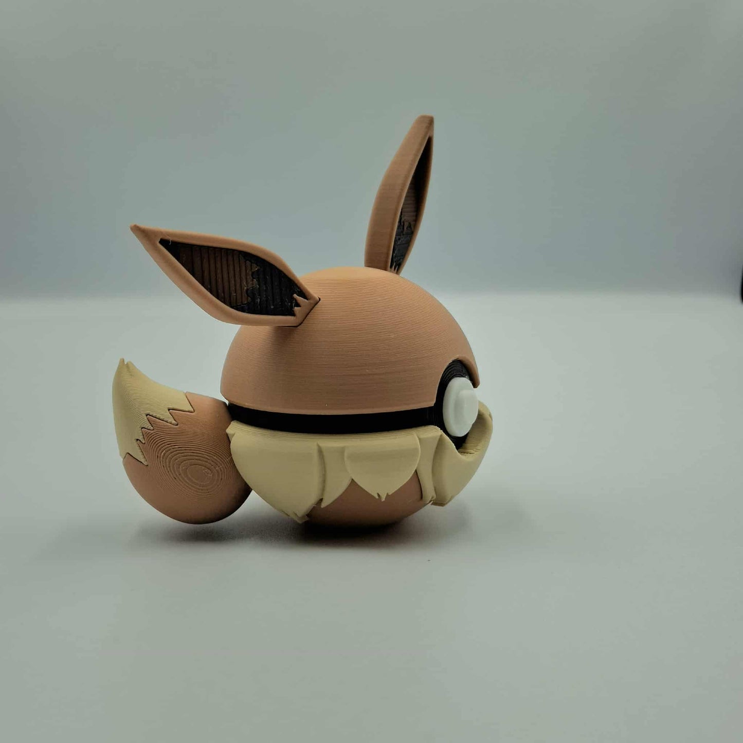 3D printed fox-inspired ball with tall ears, fluffy chest details, and curled tail on a light background.
