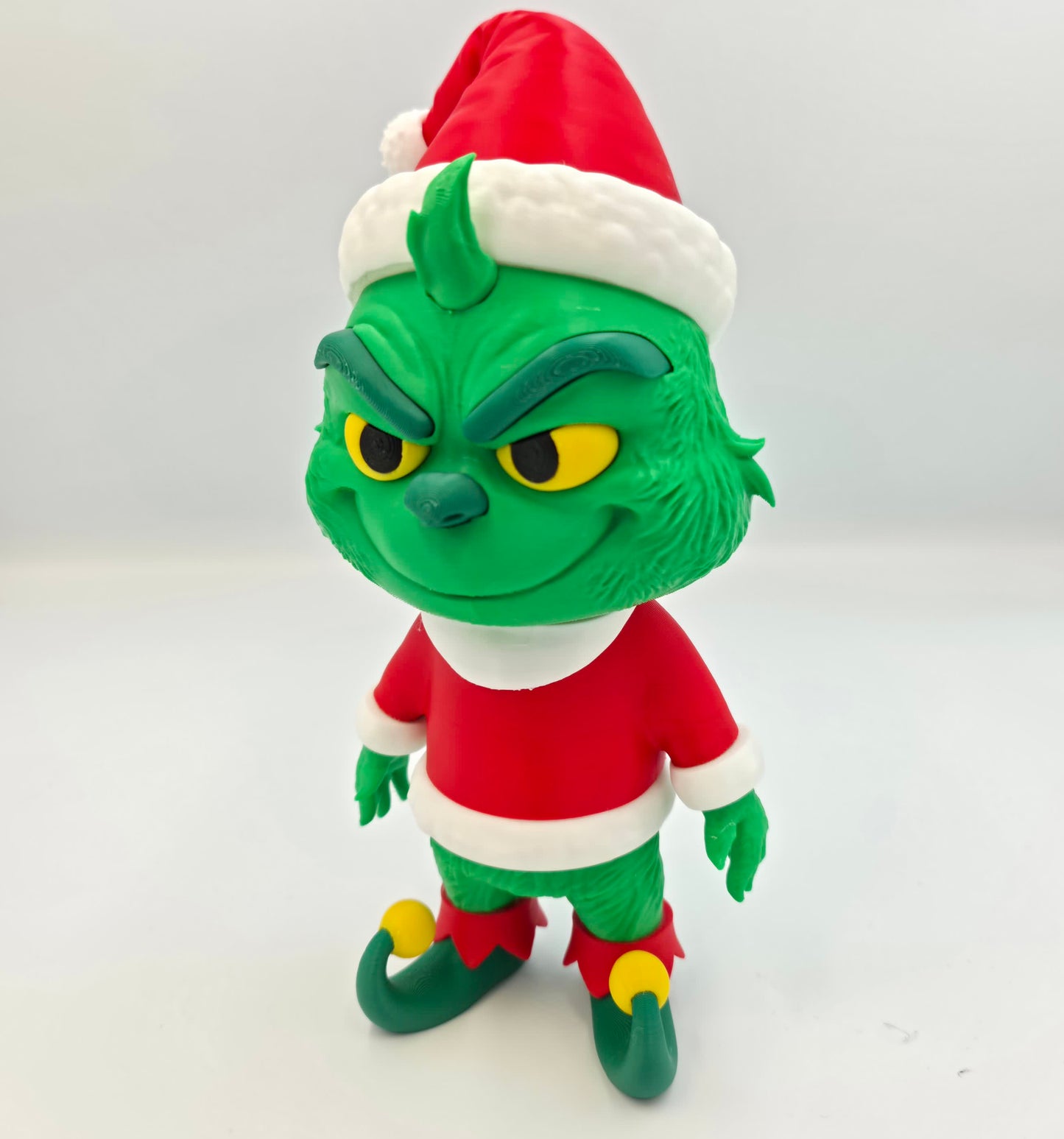 “3D printed Grinch Santa figure holding a gift bag – handmade Christmas holiday decoration in PLA.”