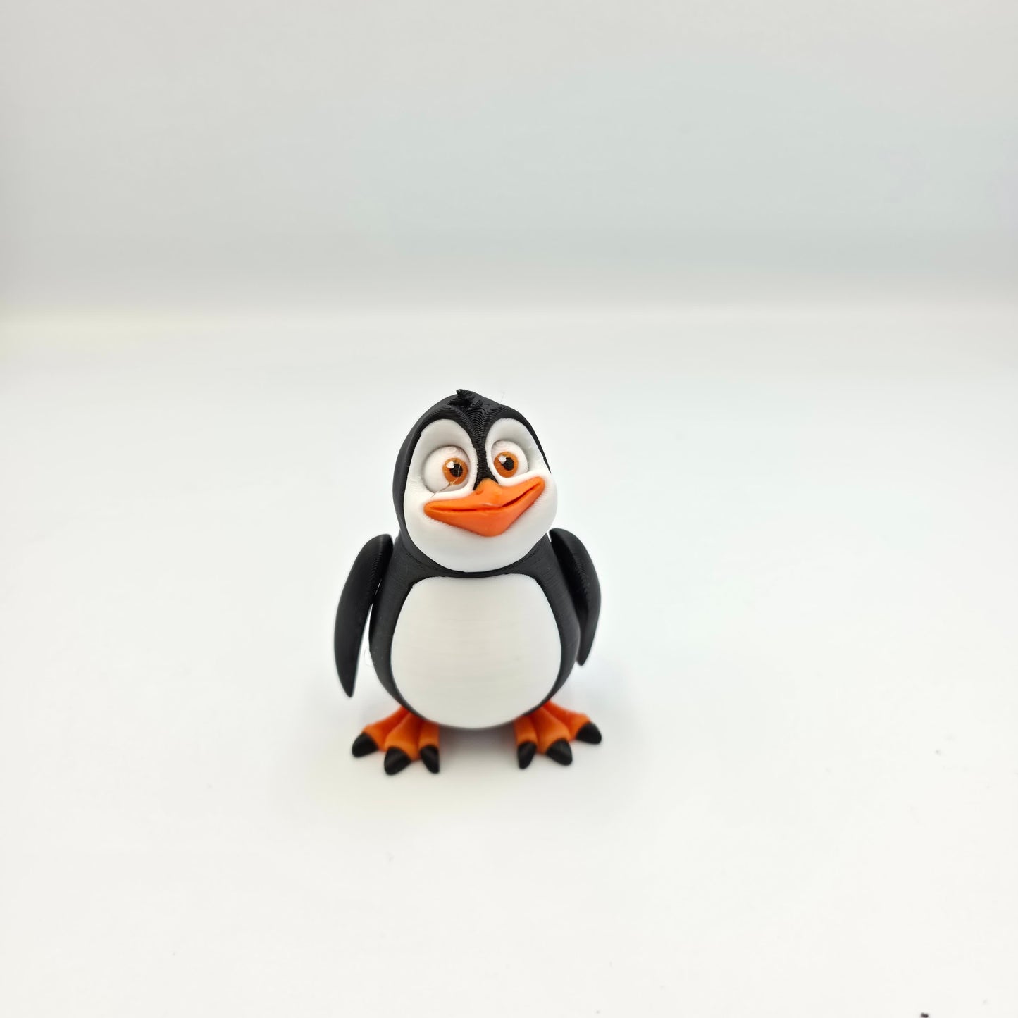 “Articulated 3D printed penguin figure with movable head, feet, and wings – cute cartoon-style toy.”
