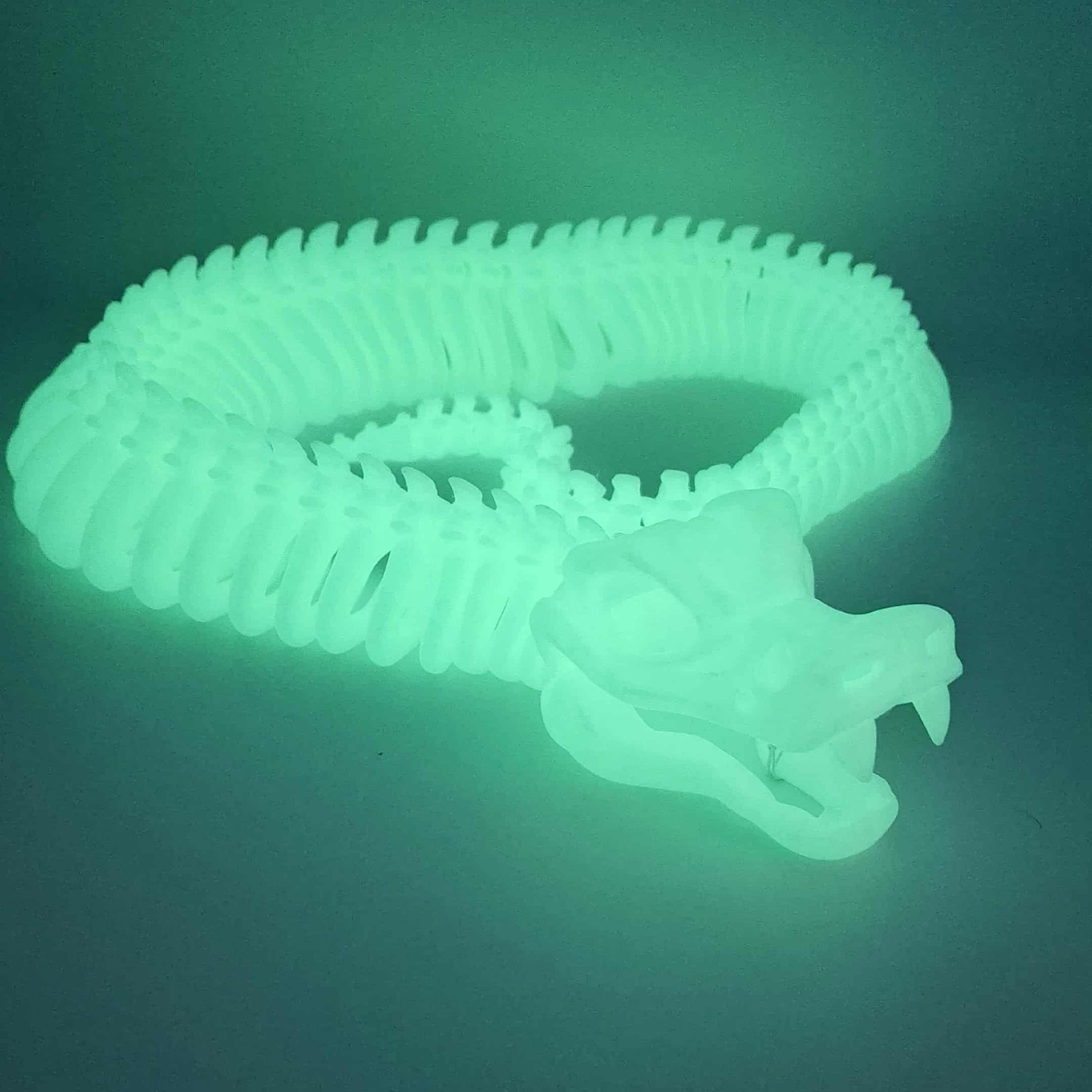 3D printed articulated skeleton snake in black and red gradient with poseable body and an opening jaw.